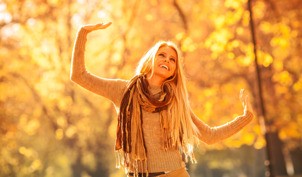 Молодая красивая девушка радуется теплому осеннему солнцу