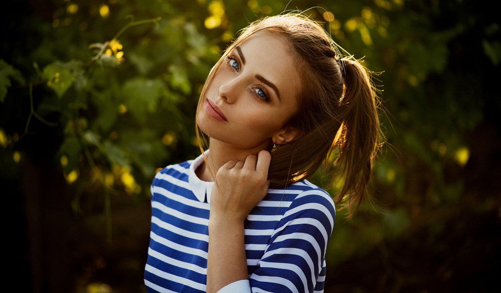 Молодая голубоглазая девушка в полосатом платье