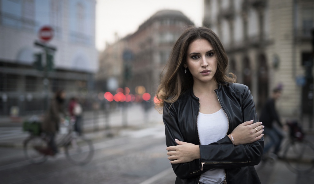 Молодая брюнетка в черной кожаной куртке