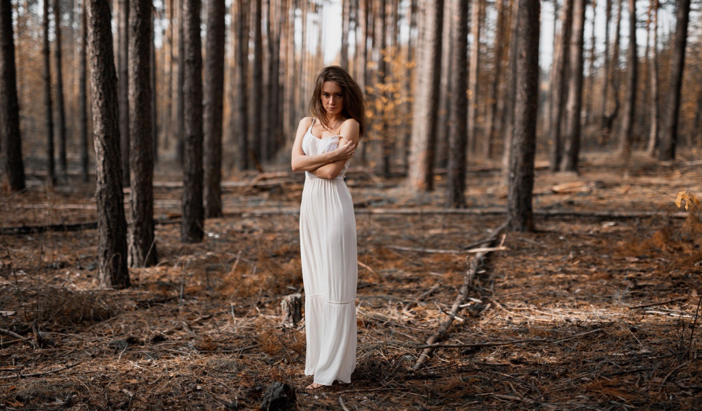 Молодая девушка в белом платье в лесу 