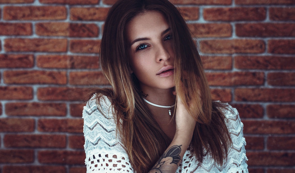 Молодая девушка с татуировкой на руке