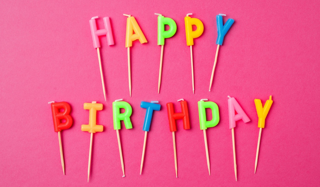 Праздничные свечи с надписью Happy Birthday на розовом фоне
