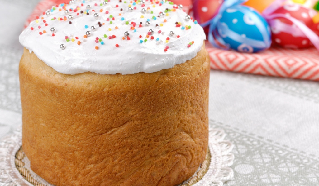 Пасхальный кулич с белой глазурью на столе 