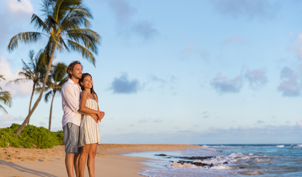 Влюбленная пара встречает закат на берегу океана