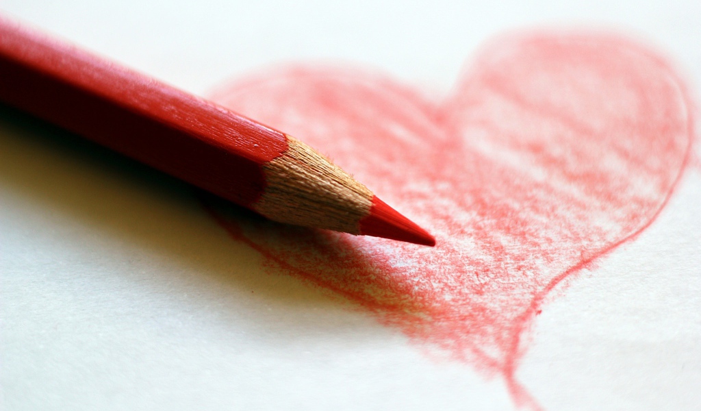 Нарисованное карандашом красное сердце на бумаге