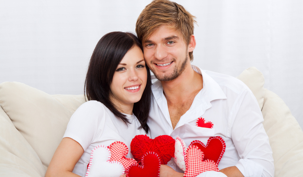 Красивая влюбленная пара с маленькими сердечками в руках