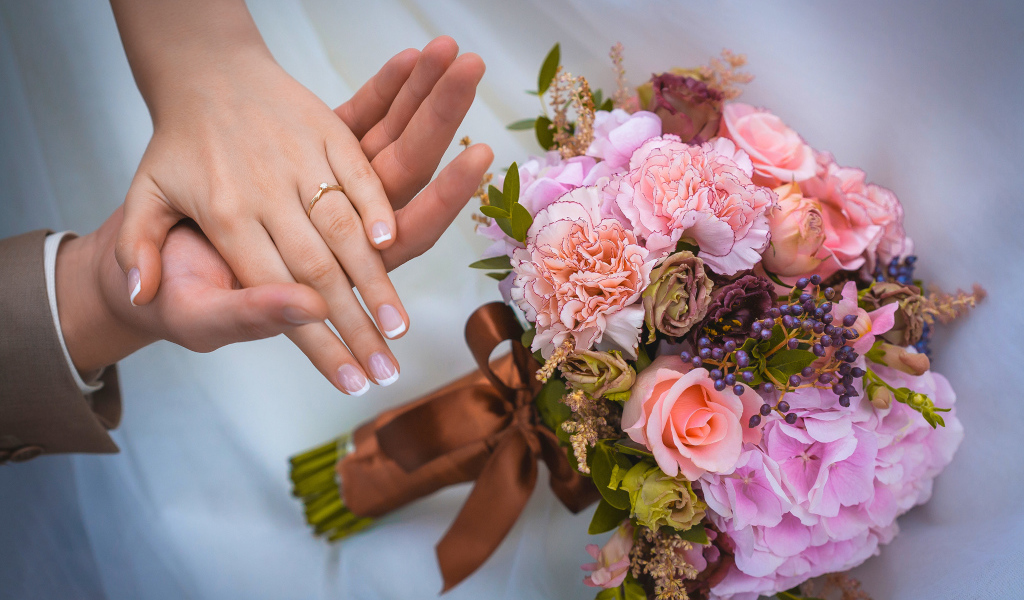 Руки влюбленной пары со свадебный букетов