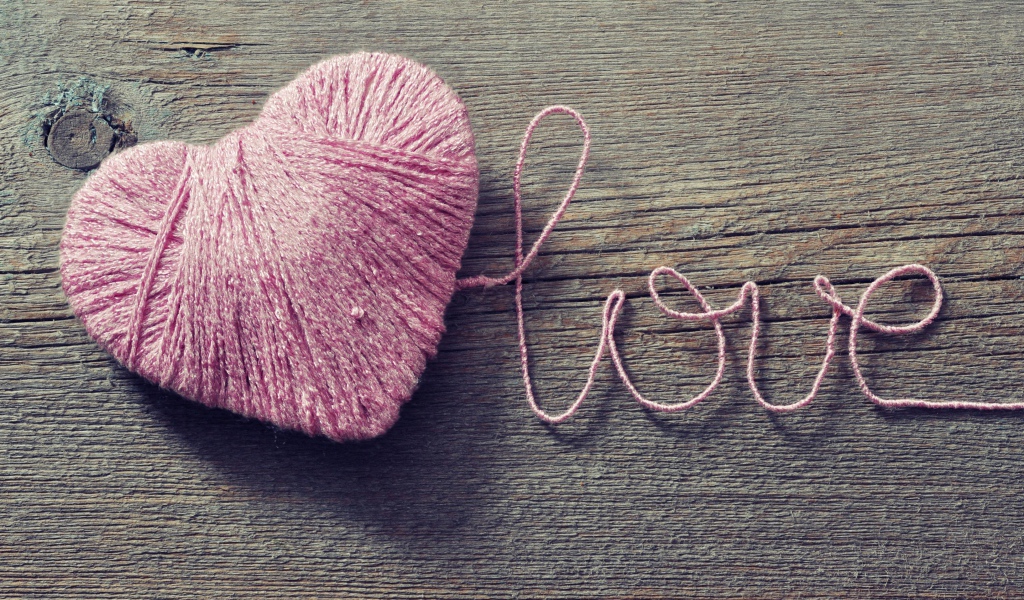 Надпись Love из розовых ниток на деревянном столе