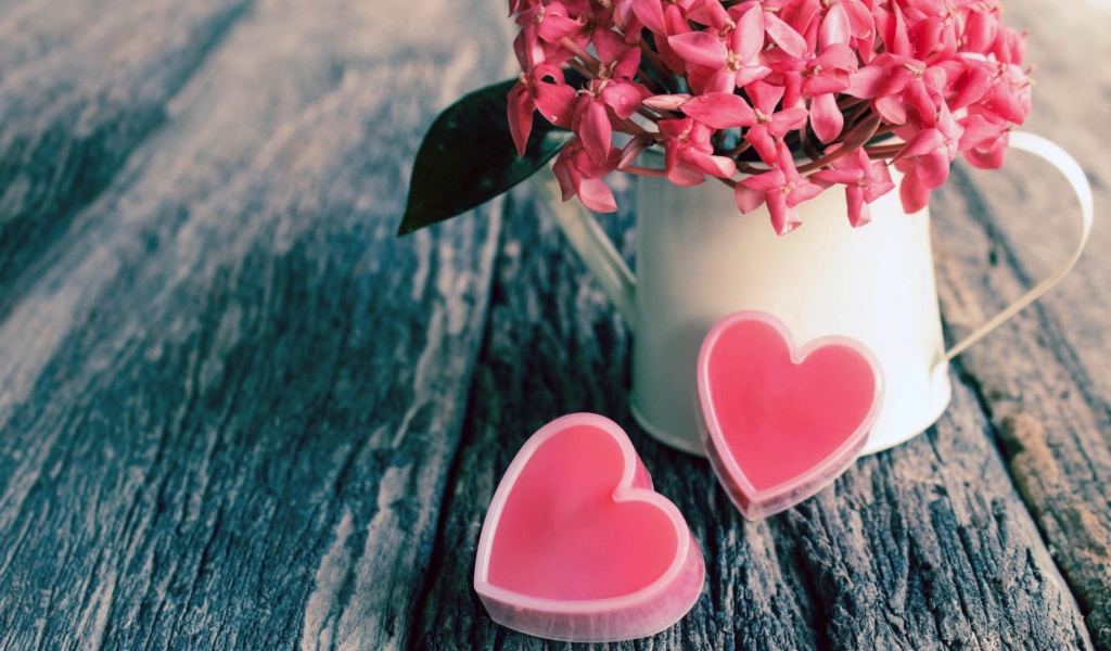 Розовые цветы в белой вазе и два розовых сердца 