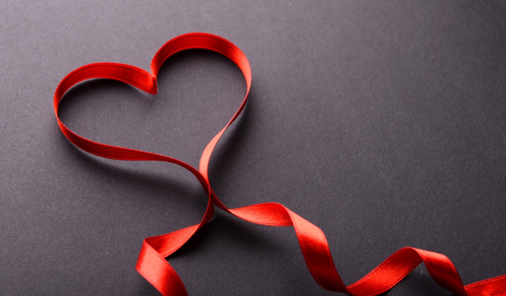Красное сердце из атласной ленты на сером фоне