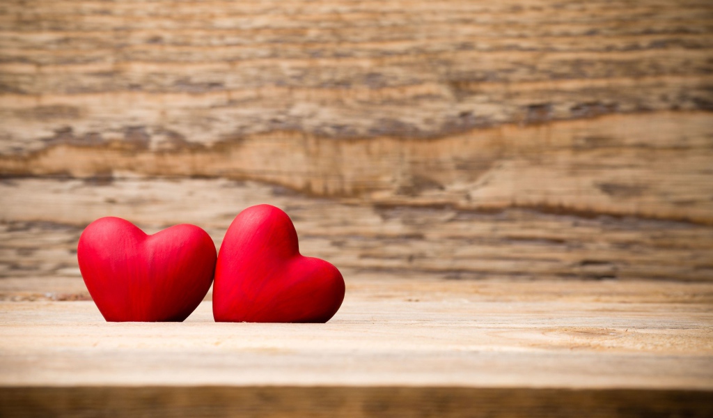 Два красных сердца лежат на деревянной лавке