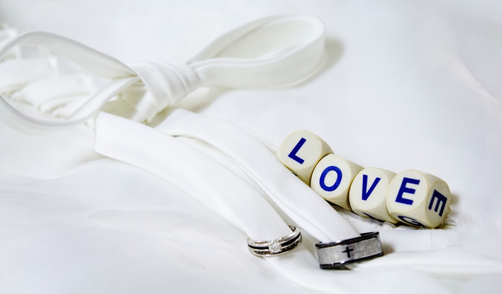 Два кольца перевязанные белой лентой и кубики с надписью любовь