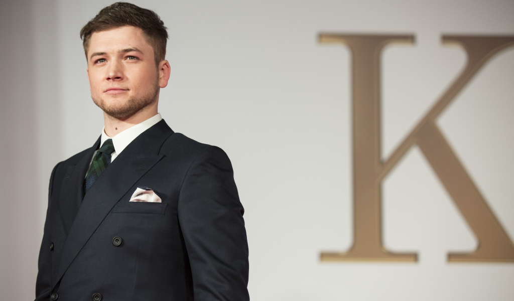 Молодой актер Терон Эгертон в черном пиджаке