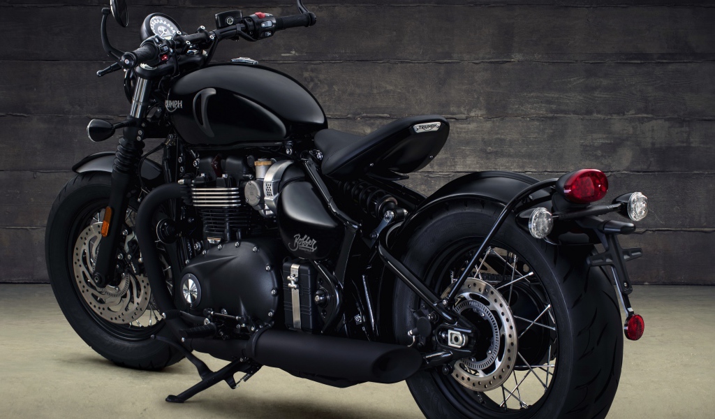 Черный мотоцикл Triumph Bonneville Bobber, 2018 вид сзади