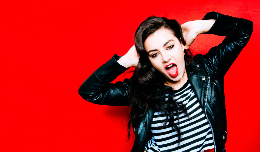 Американская певица Charli XCX позирует на красном фоне 