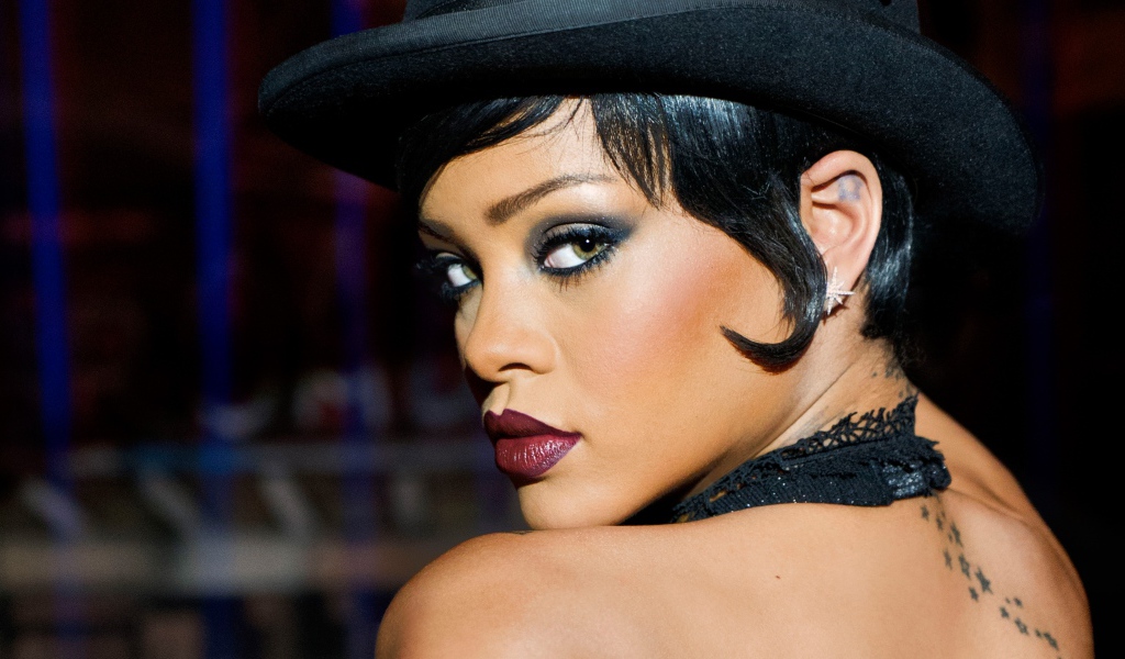 Знаменитая певица Рианна с ярким макияжем в черной шляпе