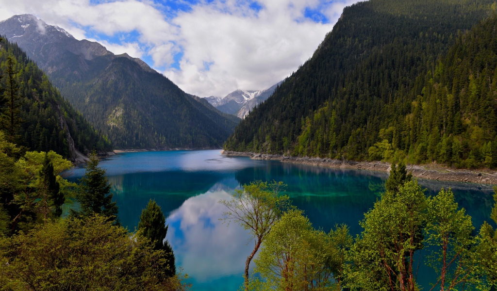 Красивое озеро у покрытых лесом гор в парке Цзючжайгоу, Китай