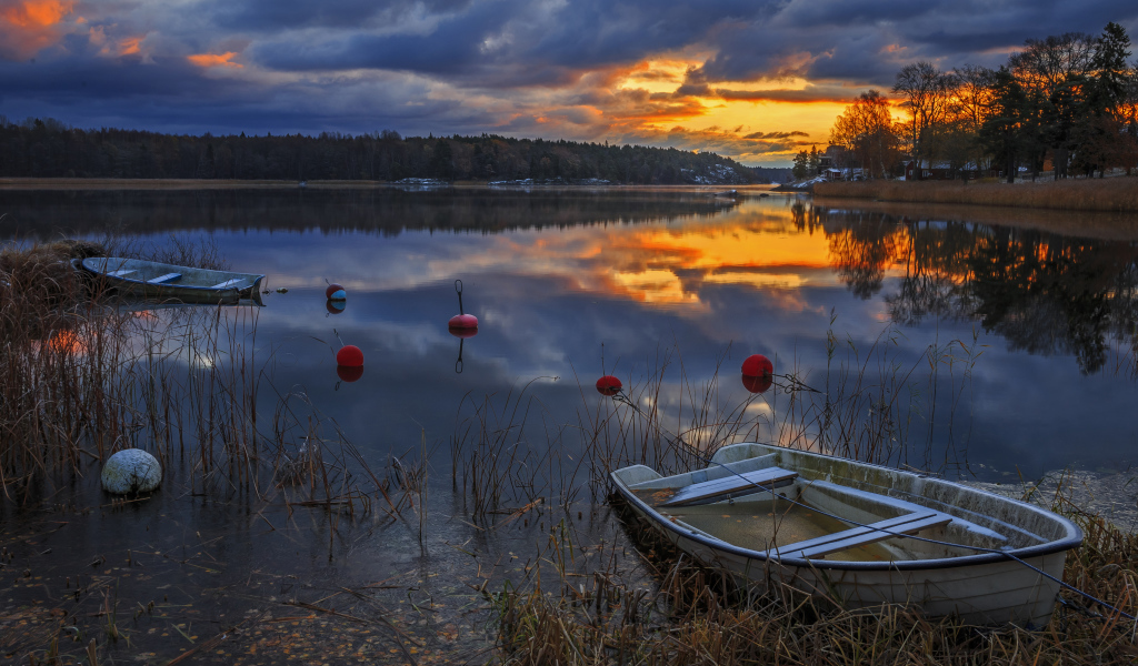 Лодки в тихом лесном озере на закате солнца