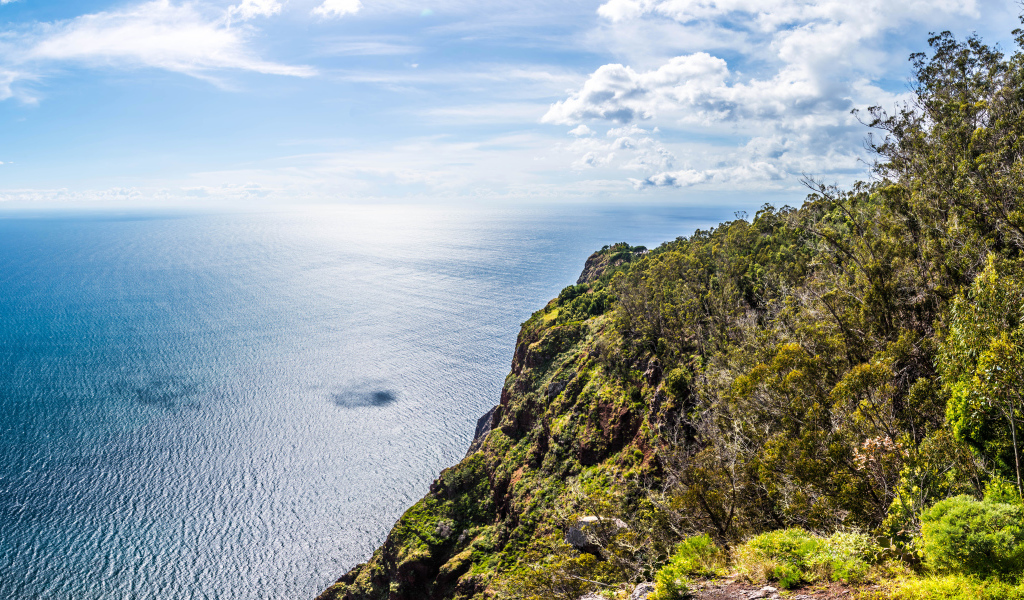 Утес на берегу океана на фоне красивого голубого неба