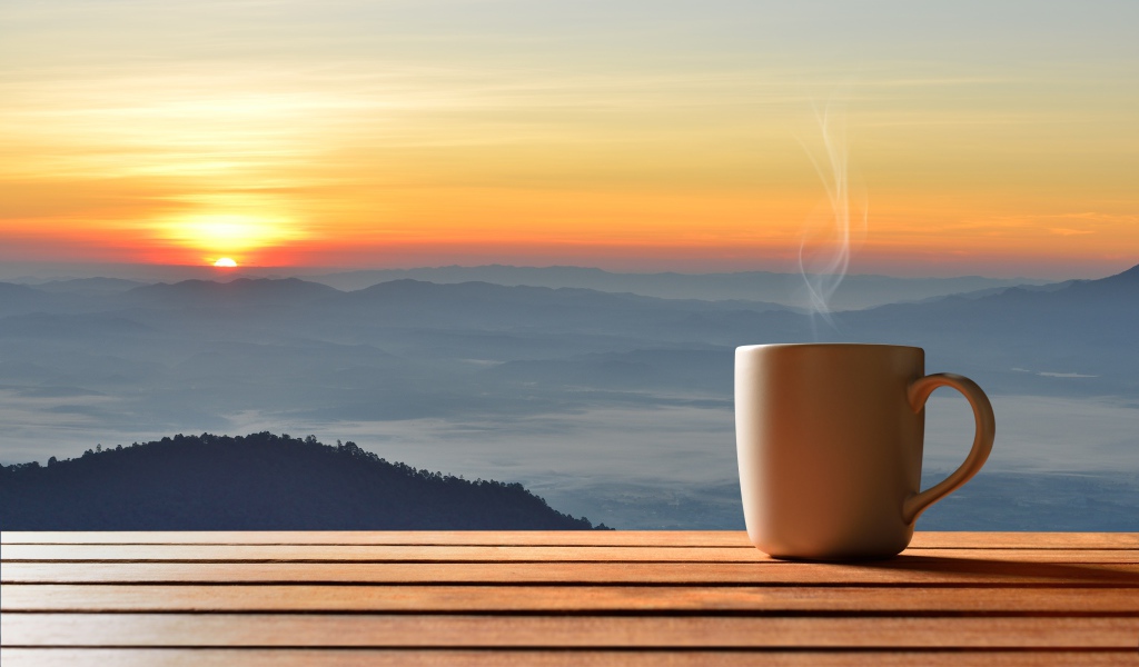 Чашка фоне на фоне горизонта с восходящим солнцем