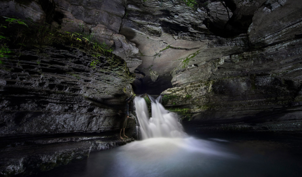 Быстрый водопад в каменной пещере 
