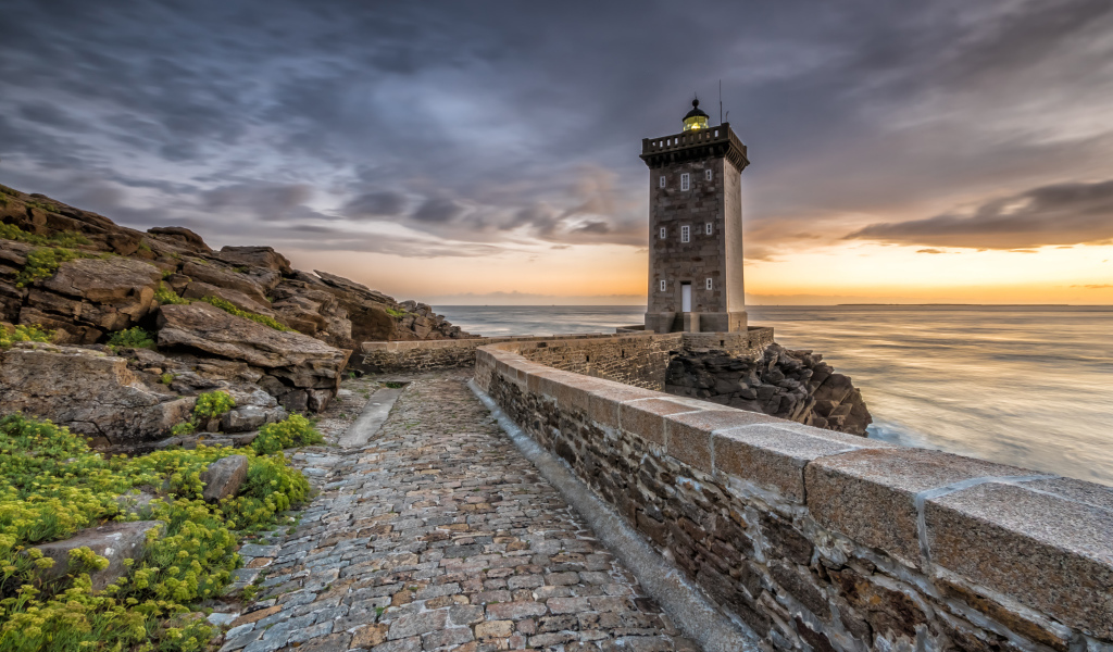 Маяк на берегу океана под красивым небом