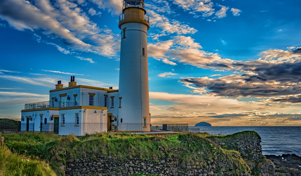 Маяк на побережье под красивым голубым небом