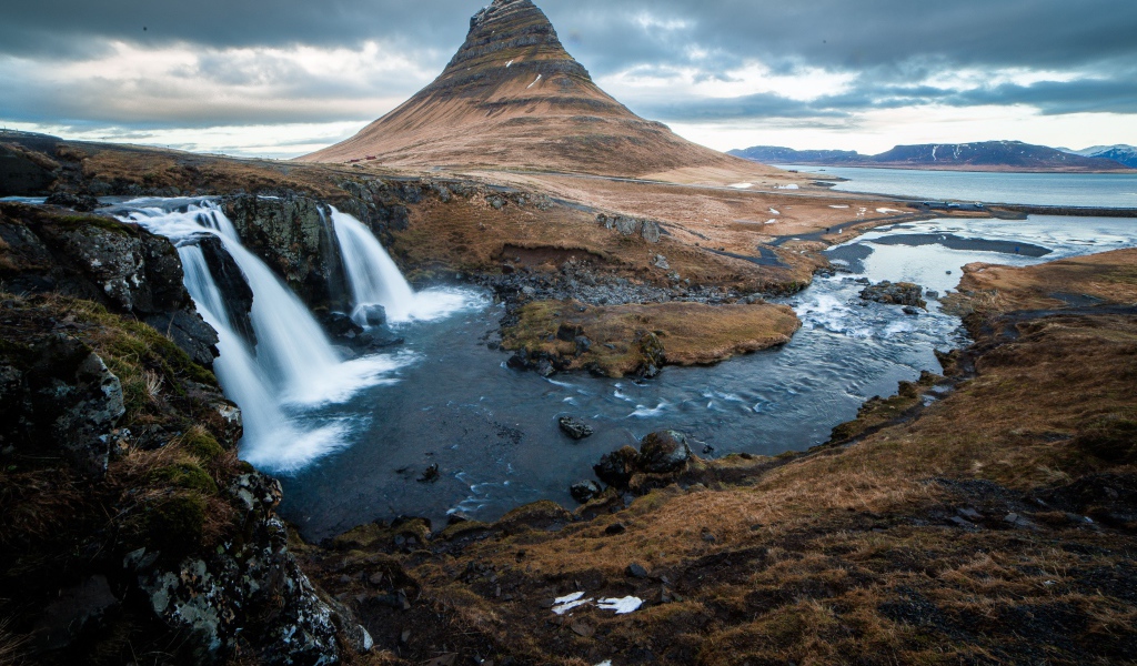 Гора и водопад у реки в Исландии  