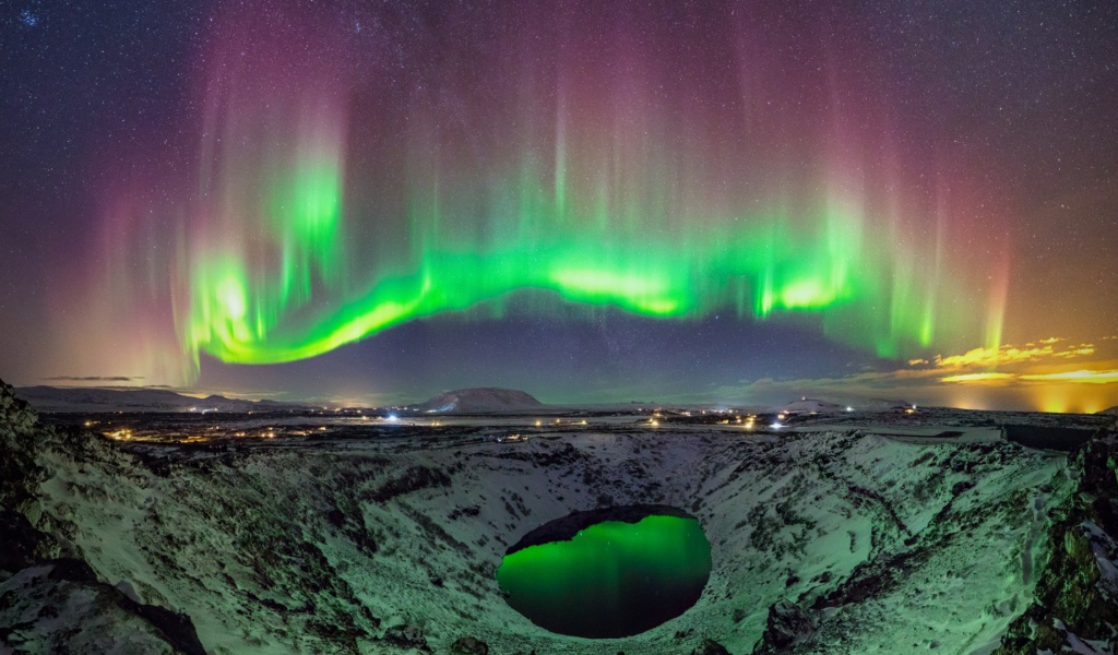 Северное сияние над заснеженным кратером вулкана 