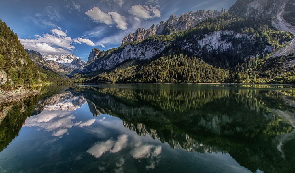 Сосны и горы отражаются в озере  