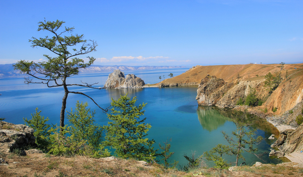 Каменные утесы у чистой воды живописного озера Байкал,  Россия