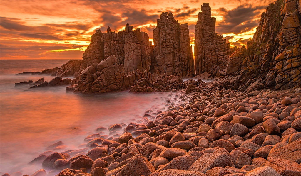 Каменные скалы в океане на закате солнца