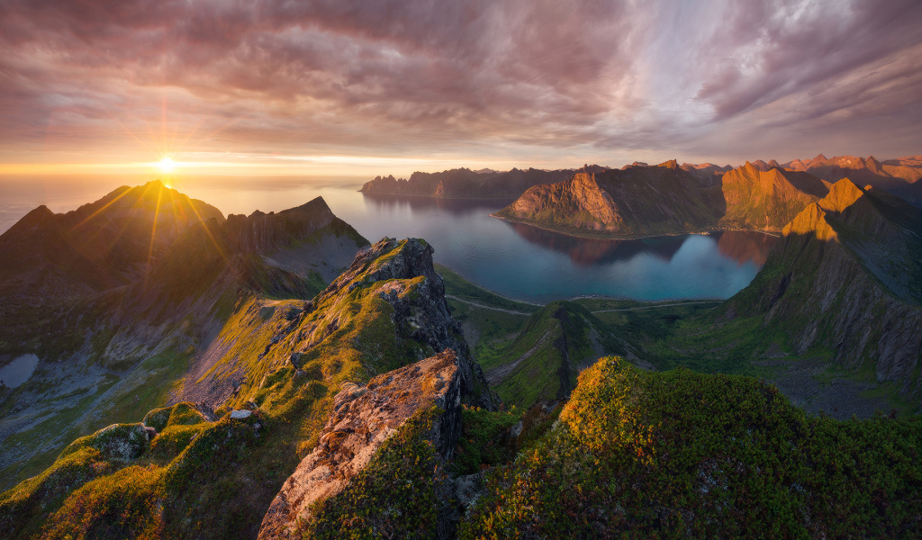 Восход солнца в красивом небе над покрытыми зеленью горами 