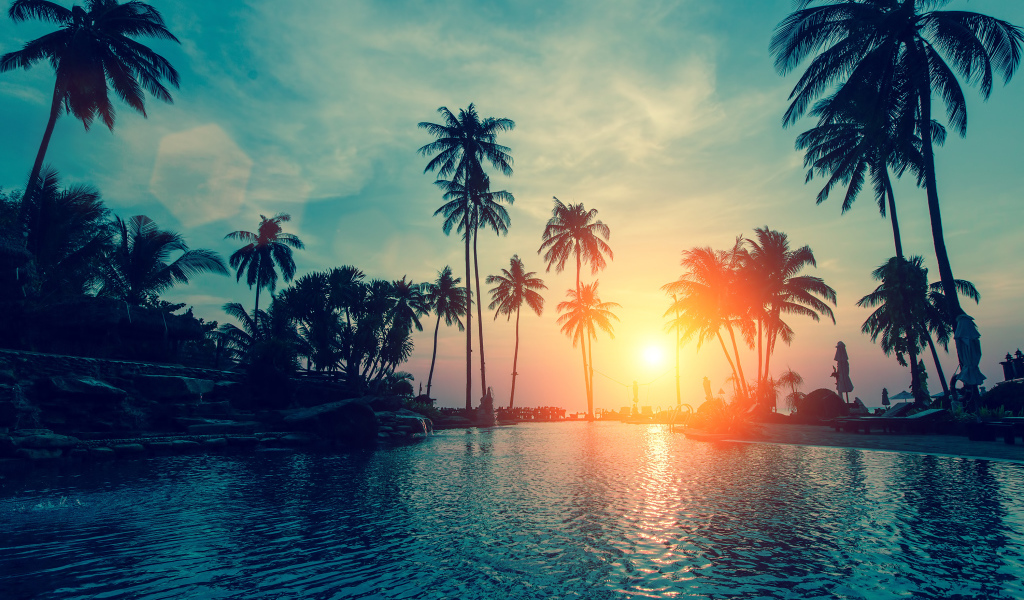 Закат яркого летнего солнца над тропическим пляжем