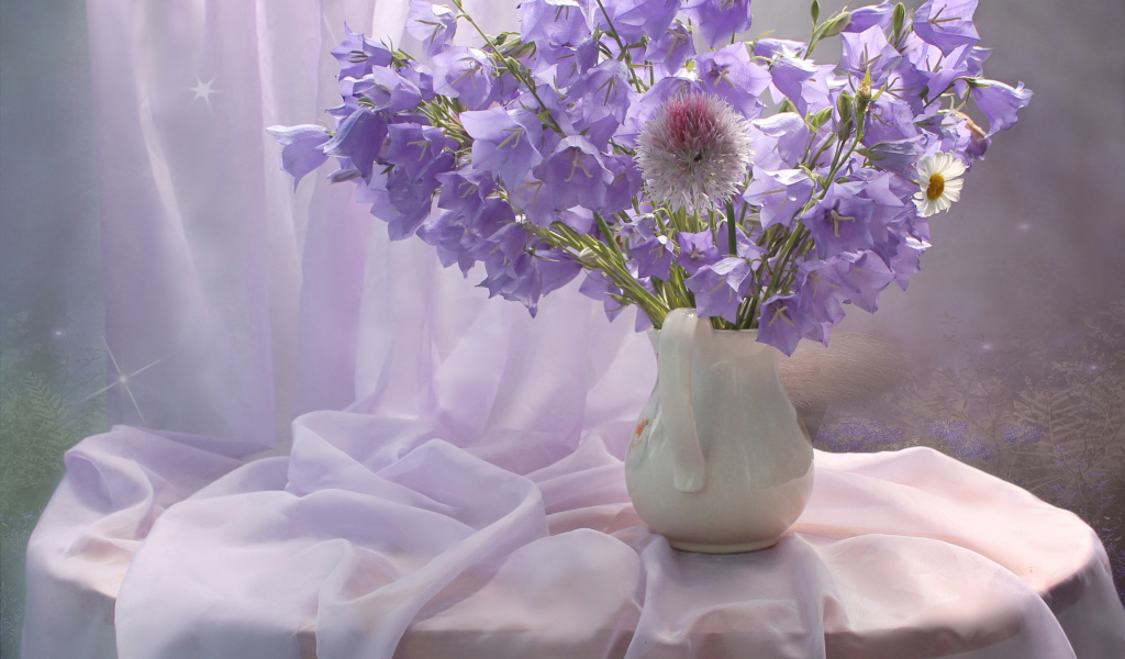 Букет фиолетовых колокольчиком в белой вазе на столе