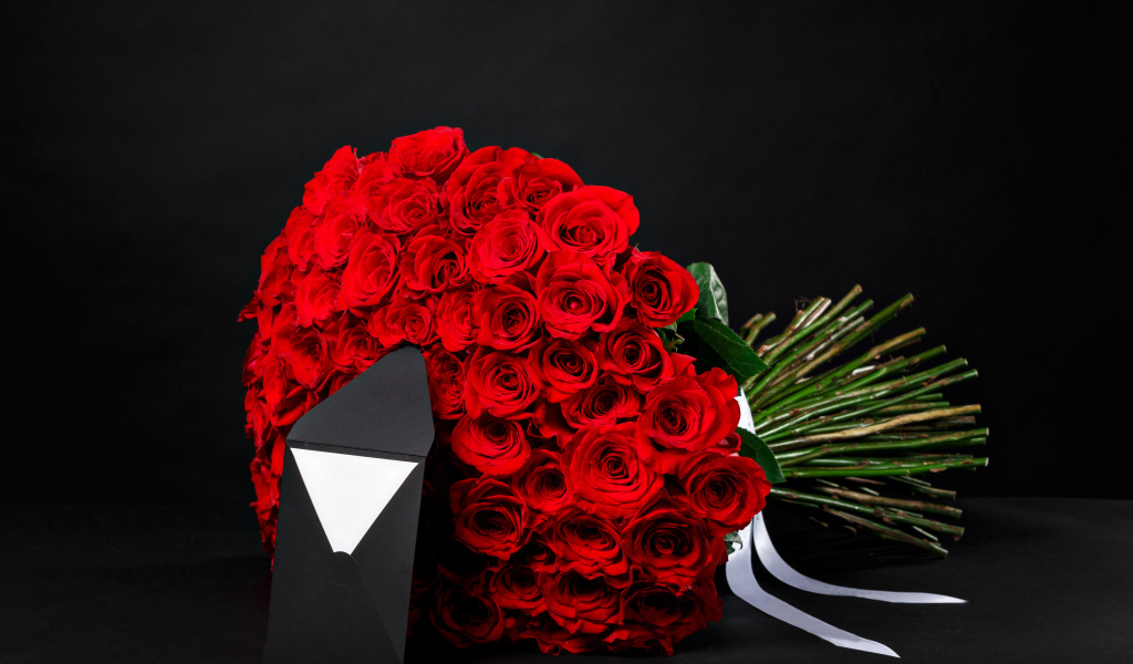 Большой букет красных роз с конвертом на черном фоне