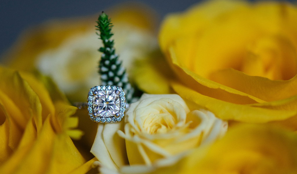 Красивые желтые розы и дорогое кольцо с бриллиантом крупным планом