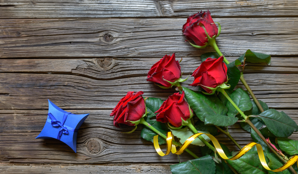Букет красных роз на столе с синей коробочкой