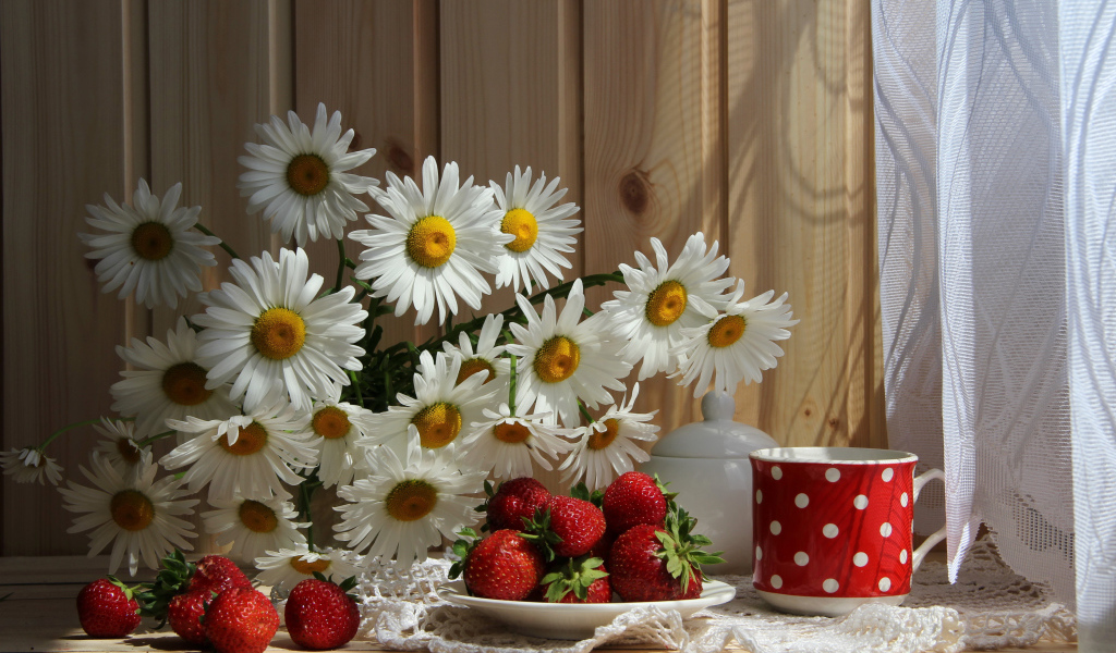 Букет белых ромашек на столе с клубникой