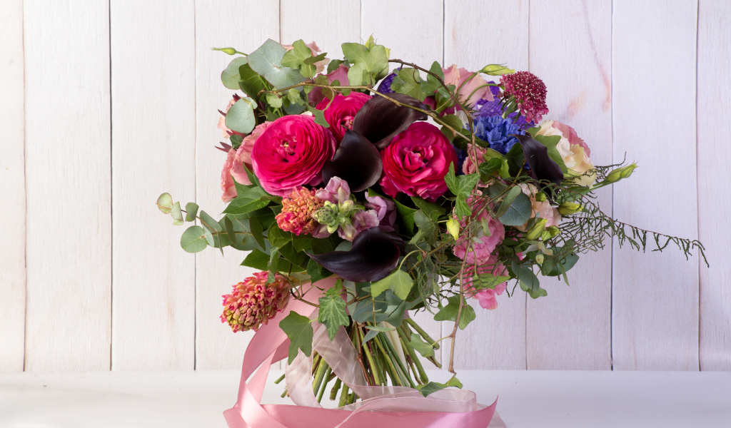 Праздничный букет с розовыми лентами на столе