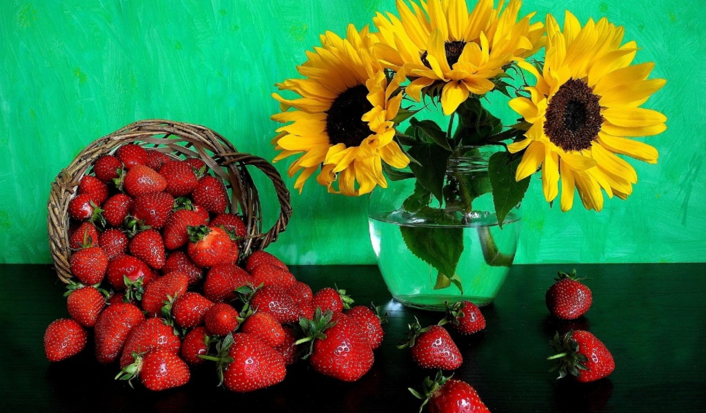 Цветы желтого подсолнуха в вазе со свежей клубникой 