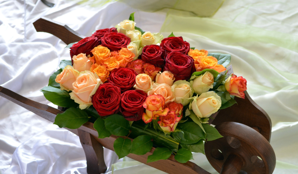 Маленькая деревянная тележка с букетом роз