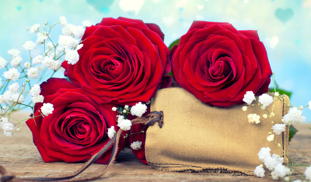 Три больших красных розы с тканевым мешочком