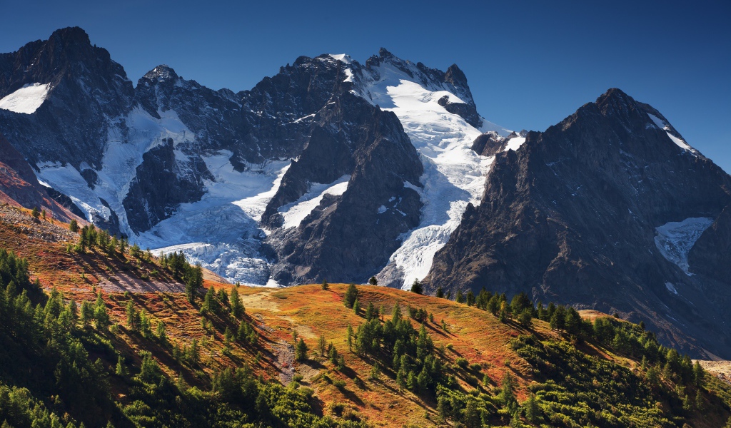 Заснеженные горы на фоне голубого неба 