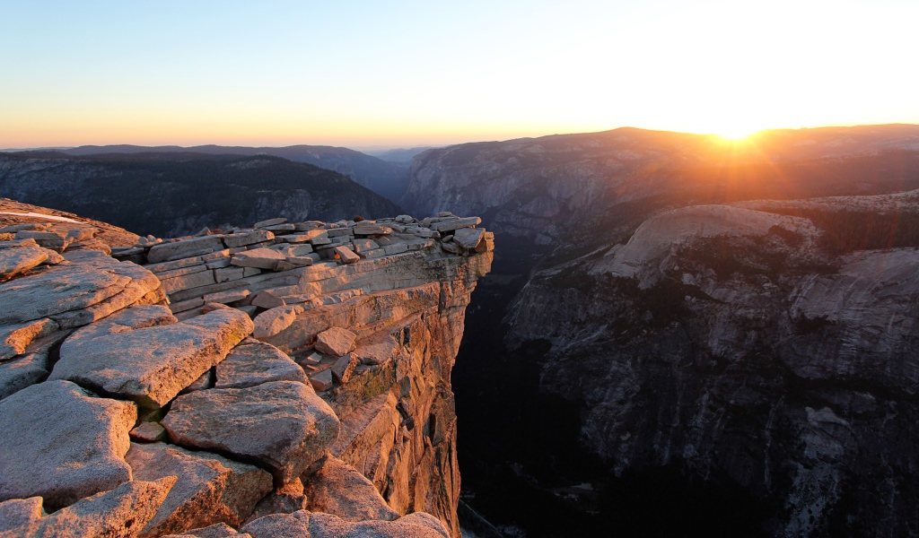 Каменные горы на фоне солнца на закате