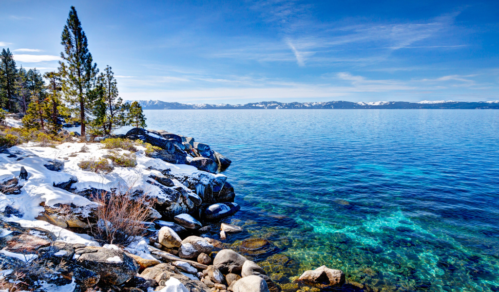 Чистая вода в озере Тахо с покрытыми снегом берегами, США