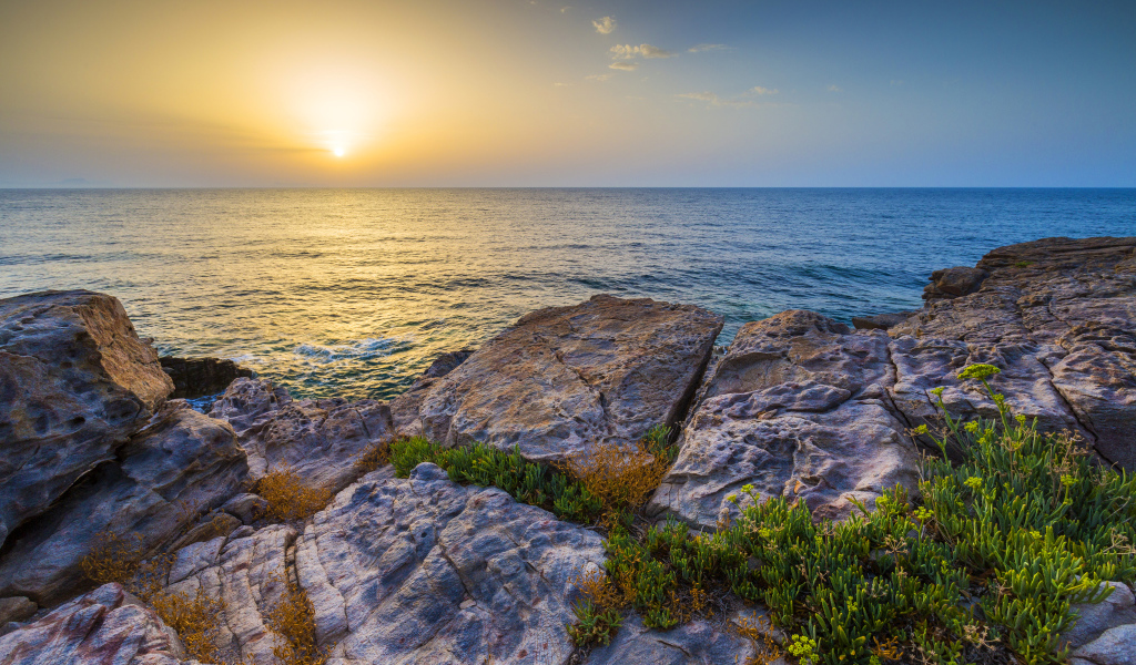 Каменные скалы на закате солнца над Средиземным морем, Греция