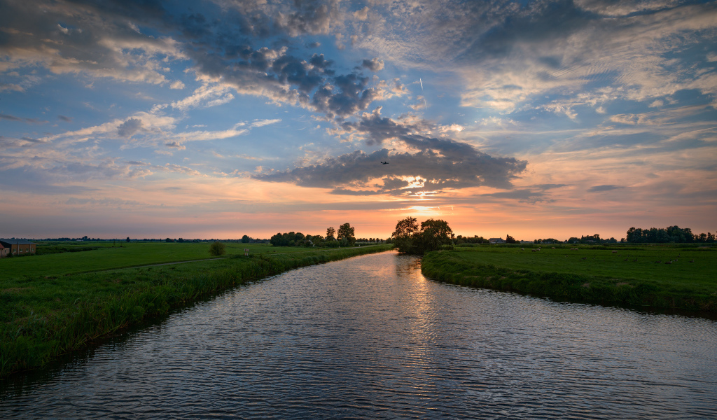 Закат солнца в облаках  над спокойной рекой