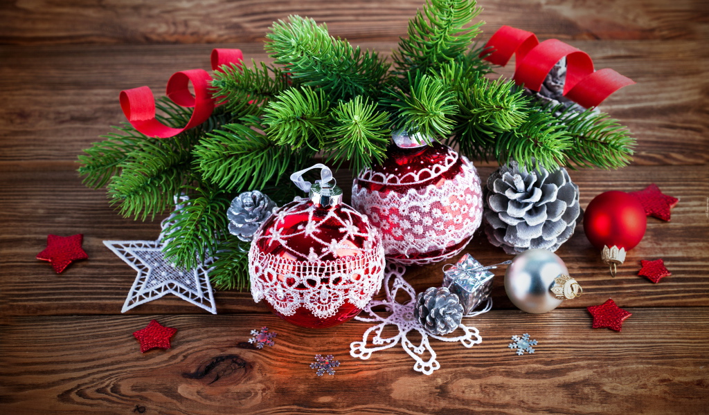 Красивые елочные игрушки с зеленой еловой веткой на деревянном столе 