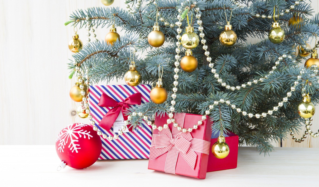 Подарки под зеленой наряженной елкой с золотыми шарами